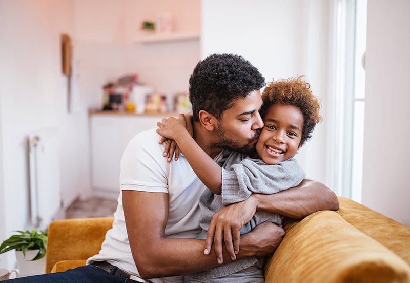 Photo of a dad and his son on the couch